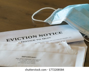 Defaulting renter with facemask receives letter giving notice of eviction from home on wooden table - Shutterstock ID 1772208584