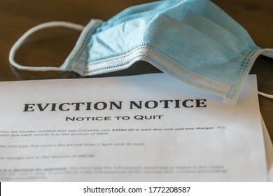 Defaulting renter with facemask receives letter giving notice of eviction from home on wooden table - Shutterstock ID 1772208587