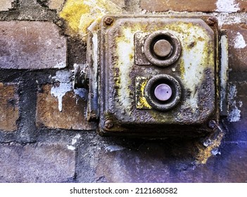 Defective Old Power Switch In A Fuse Box Made Of Rotten Plastic On A Brick Wall