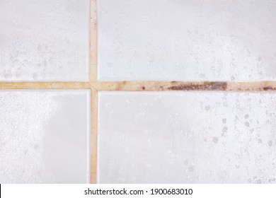 defects and disadvantages of poor-quality grouting of ceramic tile joints. Cracks, spots, darkening, yellowness of cement lime grout. - Shutterstock ID 1900683010