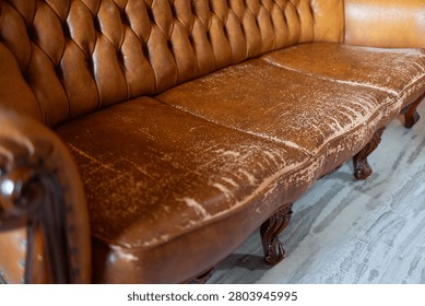 Defects on a leather sofa. Damaged to leather furniture. Close up of damaged leather soft tufted furniture. Bad quality leather