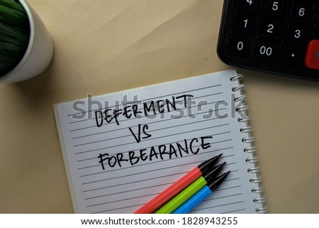 Deferment Vs Forbearance write on a book isolated on office desk.