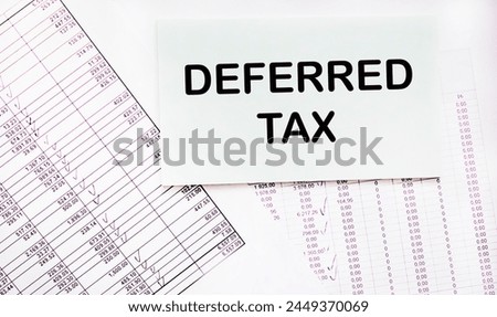 DEFERRED TAX text on notepad on graph and white background