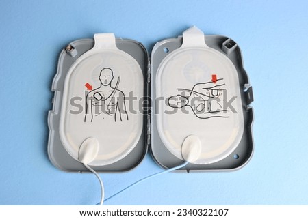 Defibrillator electrodes in the case in a light blue background 
