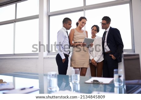 Defining the scope of their project. Shot of a group of businesspeople standing together looking at a digital tablet.