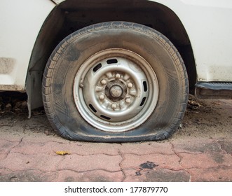 Deflated damaged tyre on car wheel.