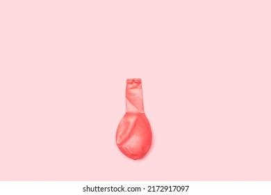 A Deflated Pink Balloon On A Pink Background With Copy Space