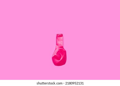 A Deflated Pink Balloon On A Pink Background With Copy Space