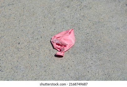 Deflated Pink Balloon On Concrete