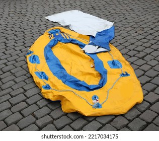 deflated rubber dinghy on the cobblestones for sale in yellow and blue - Shutterstock ID 2217034175