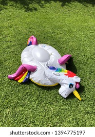 A Deflated Unicorn Pool Inflatable On Grass.