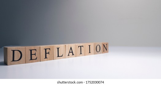 Deflation text from wooden cubes. With spot light in the studio and white background.