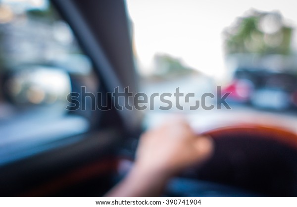 defocus or blured of hand on car wheel with\
road and car outside as\
background