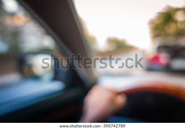 defocus or blured of hand on car wheel with\
road and car outside as\
background