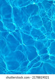 Defocus blurred blue water in swimming pool rippled water detail background. Water surface in the sea, ocean background. Water is an inorganic, transparent, tasteless, odorless, and nearly colorless.
