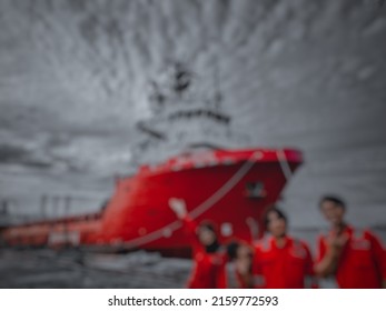 Defocus And Blurred Image Background Of Four Seafarer, One Of Which Is A Woman, Posing In Front Of A Supply Ship Docked At The Shipyard. Woman Seaman For Emancipation And Gender Equality For All Work