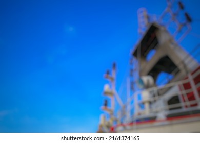 Defocus And Blurred Image Background Of Mast Head Supply Ship Bridge With Lots Of Antennas And Satellites Under Blue Sky. Negative Space, Copy Space