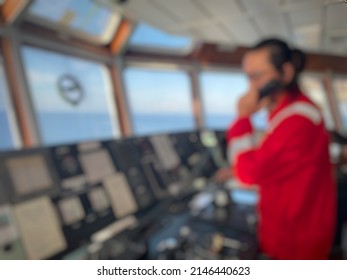 Defocus And Blurred Image Of A Long-haired Male Sailor Wearing A Red Coverall Was Piloting The Ship, Maneuvering The Ship To Dock. A Seafarer Under Controlling Vessel Due To Maneuver For Alongside 