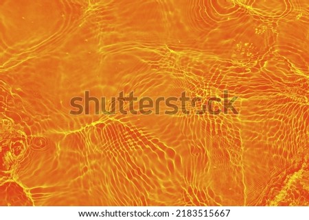 Defocus blurred orange water shining in the sea. rippled water detail background. The water surface in the sea, ocean background. Water wave under sea texture background.