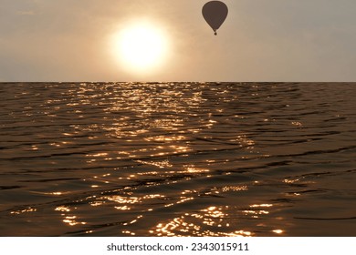 Defocus blurred transparent orange sea with sunset and hot air Balloon. water surface texture with splashes and bubbles. Trendy abstract nature background. Water waves in sunlight with copy space. - Powered by Shutterstock