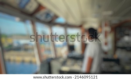 defocus and blurref image of a male sailor, seafarer at bridge for maneuvering to lean the ship, alongside at the jetty. berthing