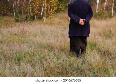 Defocus Freedom Old Woman, Female Person Walking In Autumn Meadow. Fall Dry Grass. Old People Leaving Home Or Lost. Harmony Concept. Nature Background. Out Of Focus.