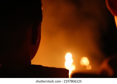 Defocus Intense Fire With The Profile Silhouette Of A Person. Fire And People. Medium Close-up Of A Man Trapped In Fire Crying For Help And Coughing. Out Of Focus.