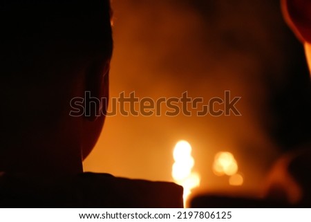 Defocus intense fire with the profile silhouette of a person. Fire and people. Medium close-up of a man trapped in fire crying for help and coughing. Out of focus.