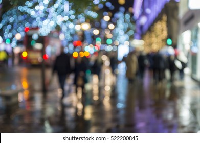 Defocus Night View Of Holiday Lights And Christmas Shopping Crowds On A Wet Night On Oxford Street, In London, UK