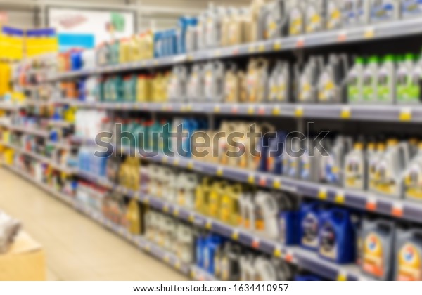 Defocus of a shelf of an automotive\
oil store. Colored plastic cans with machine oil and car cosmetics\
in a retail store. Blurred backdrop wallpaper\
background