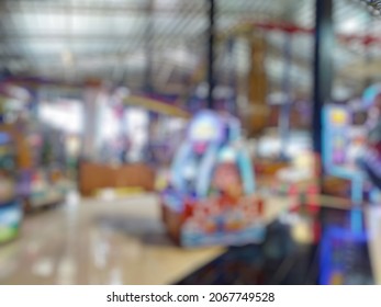 Defocused Abstract Background Of Arcade Game Machine Shop. Bokeh Indoor Game Zone. 