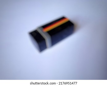 Defocused Abstract Background Of Black Cube With Red Yellow Stripes