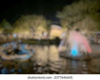 Defocused abstract background of ight view at Bale Mas Kemambang Park which has a fountain pool and water bike rides.