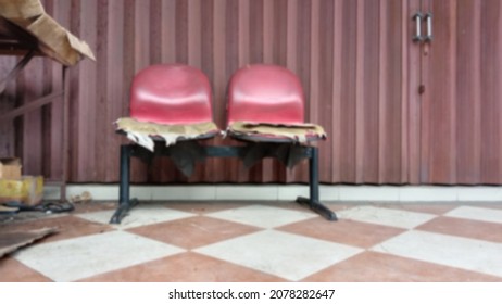 defocused abstract two broken red waiting chair in front of rollong door