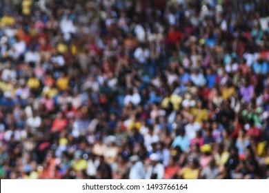 Defocused Audience At Stadium, Dark Colored Scene. Large Group Of People, Crowd Attendance In Arena