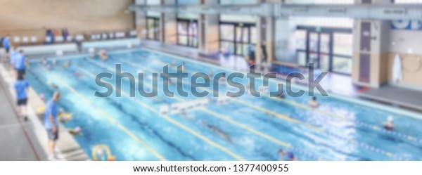 Defocused background with aerial view of a\
swimming pool indoor. Intentionally blurred post production for\
bokeh effect