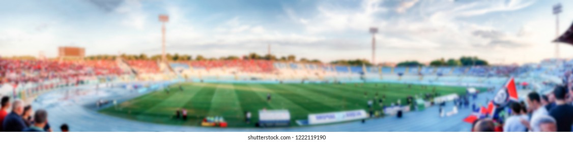 Defocused Background Of A Football Stadium. Intentionally Blurred Post Production For Bokeh Effect