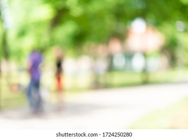 Defocused Background Of Summer Park With  People Passing By