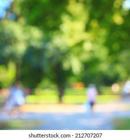 Defocused Background Of Summer Park With Walking People