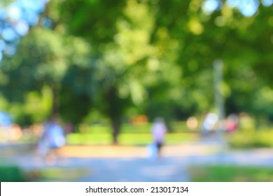 Defocused Background Of Summer Park With Walking People