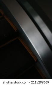 defocused black dark escalator texture with the aluminum and yellow lines moving at the mall