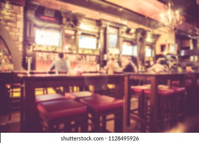 Defocused blur from Irish pub with unrecognizable people at the bar and vintage filter tone. - Powered by Shutterstock