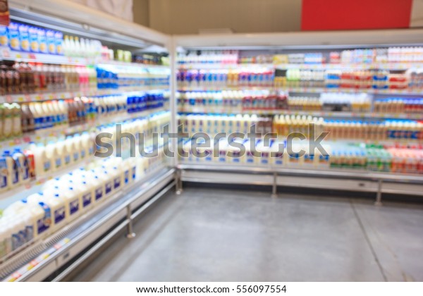 Defocused blur of supermarket\
shelves with dairy products. Blur background with bokeh. Defocused\
image