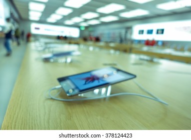 Defocused blur of tablet in a eletronics shop - New technology addiction concept - Soft blue filtered look - Defocused image