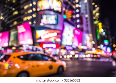 Defocused Blur Of Times Square In New York City With Lights At Night And Taxi Cab