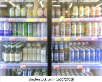 Defocused Blurred Background, Grocery Store: Refrigerator Full Of Beer. Beer In Glass And Aluminum Cans In The Store.