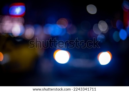 Defocused, blurred photo of the narrow street at night while car passing on the way can be used as background