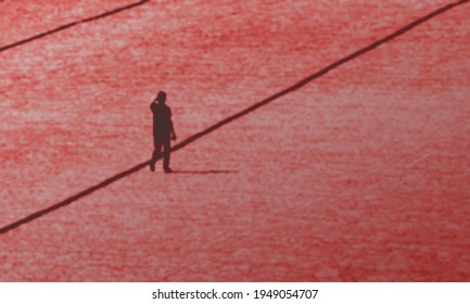 Defocused And Blurred Photo Of Red Square, Moscow, Man Walking Alone. Uncertain Future Red Background Concept.