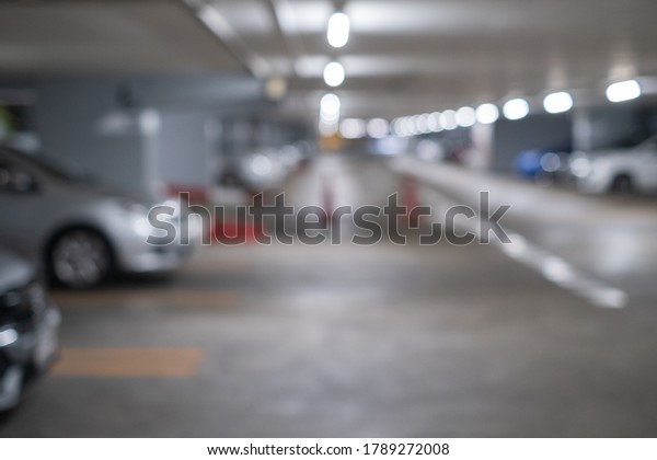 Defocused\
blurry car park background in shopping\
mall.