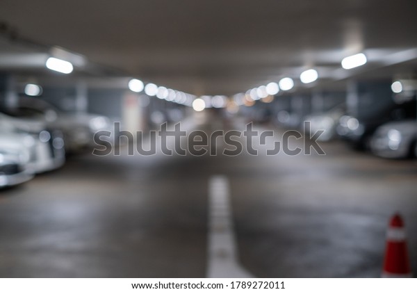 Defocused\
blurry car park background in shopping\
mall.